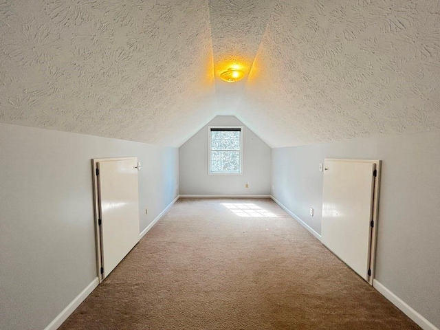 additional living space featuring baseboards, carpet, and vaulted ceiling