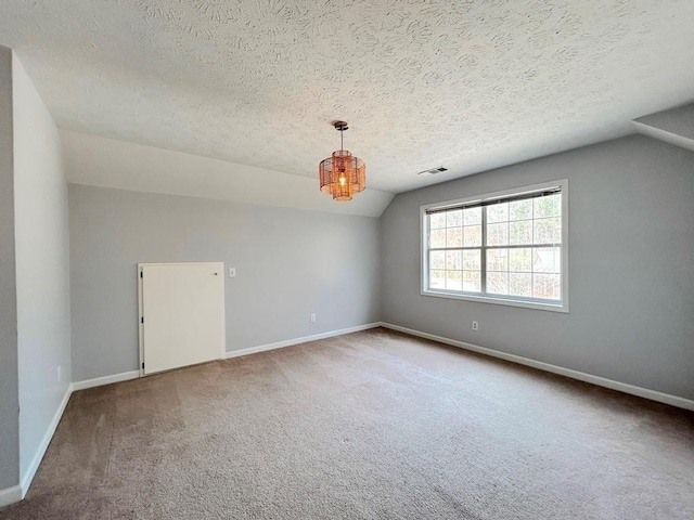 empty room featuring lofted ceiling, baseboards, visible vents, and carpet floors