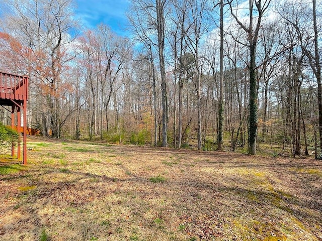 view of yard featuring a wooden deck and a forest view