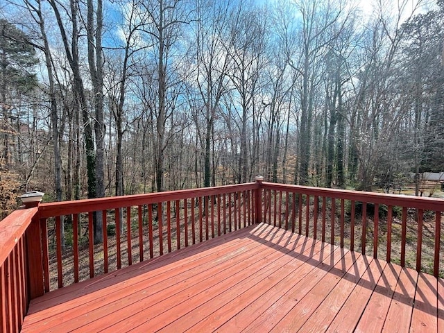 wooden terrace featuring a wooded view