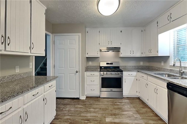1011 Darvin Ln NW, Kennesaw, GA 30144 - kitchen featuring stainless steel appliances, under cabinet range hood, wood finished floors, white cabinetry, and light stone counters