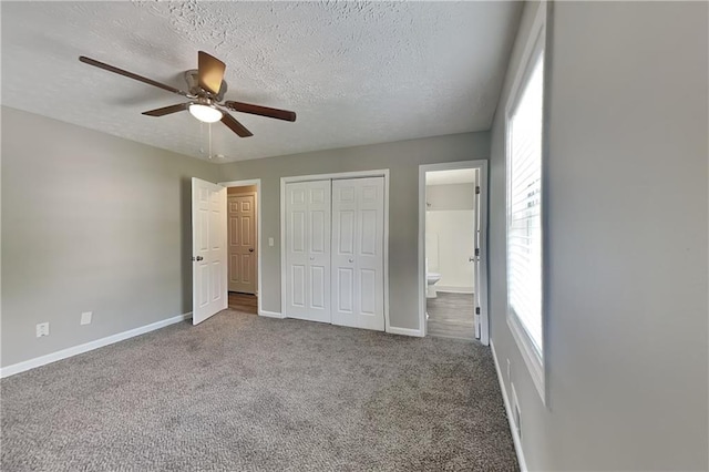 1011 Darvin Ln NW, Kennesaw, GA 30144 - unfurnished bedroom featuring a textured ceiling, carpet, a closet, connected bathroom, and ceiling fan