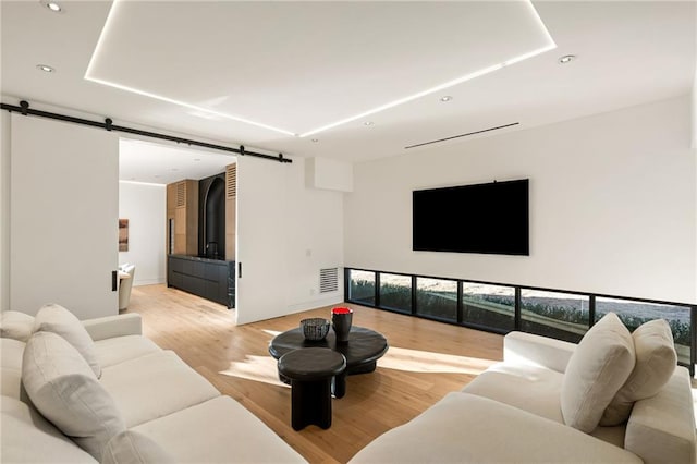 living room with light hardwood / wood-style flooring and a barn door