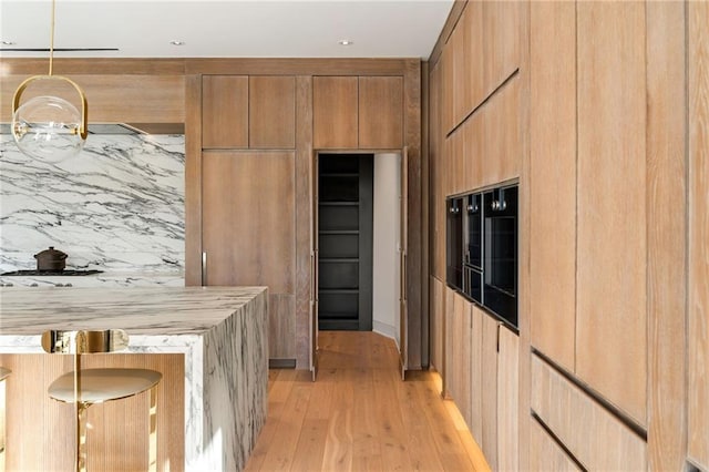 kitchen with hanging light fixtures and light hardwood / wood-style flooring