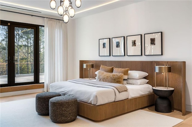 bedroom with light hardwood / wood-style floors and a notable chandelier