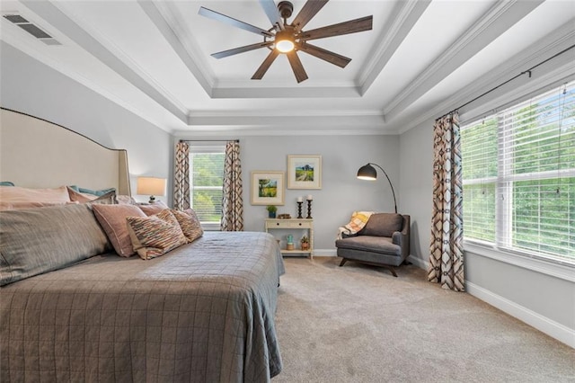 bedroom with a tray ceiling, light colored carpet, baseboards, ornamental molding, and visible vents