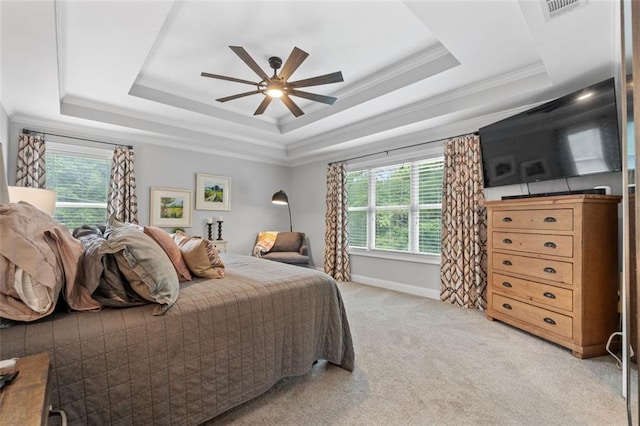bedroom featuring a raised ceiling, visible vents, light colored carpet, and multiple windows