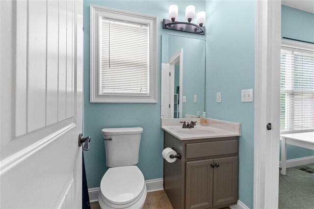 bathroom featuring visible vents, toilet, baseboards, and vanity