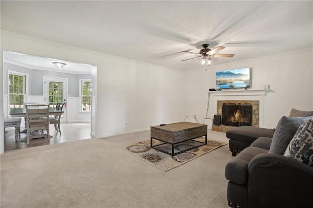 living room featuring crown molding, a fireplace, plenty of natural light, and ceiling fan