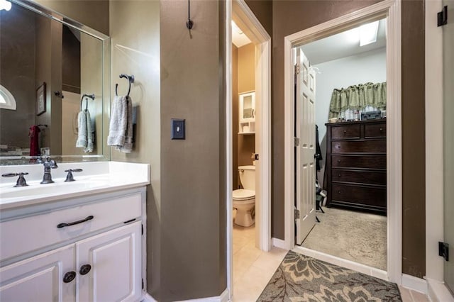 bathroom with toilet, vanity, and tile patterned floors