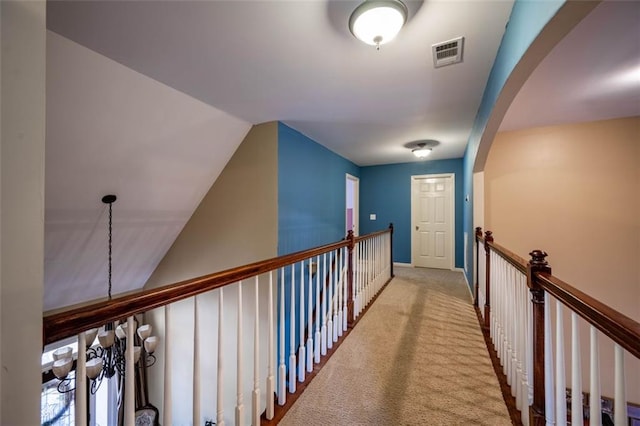 hall featuring light carpet and lofted ceiling