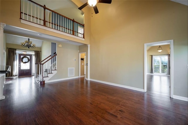 unfurnished living room with a high ceiling, a healthy amount of sunlight, and dark hardwood / wood-style floors