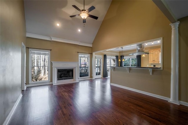 unfurnished living room featuring high vaulted ceiling, ceiling fan, dark hardwood / wood-style flooring, and ornate columns