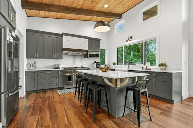 897 Faraday Dr, Ellijay, GA 30540 - kitchen featuring appliances with stainless steel finishes, a wood ceiling with exposed beams, light countertops, a breakfast bar area, and dark wood-style flooring