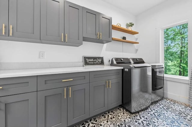 897 Faraday Dr, Ellijay, GA 30540 - laundry area with cabinet space, washing machine and dryer, plenty of natural light, and light tile patterned flooring