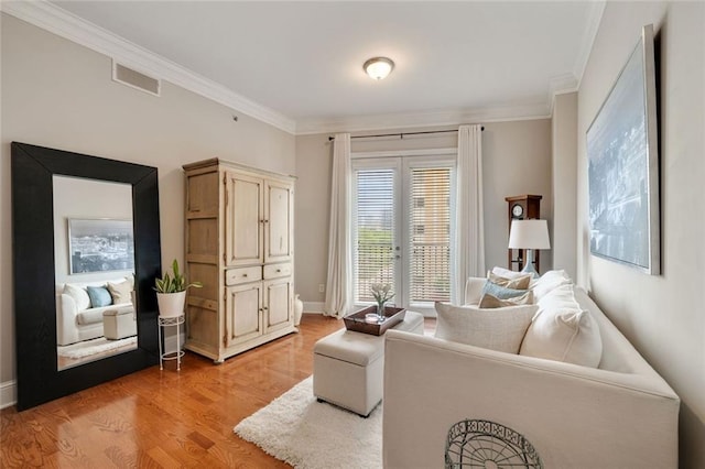 living room featuring crown molding, light wood-style floors, french doors, and baseboards