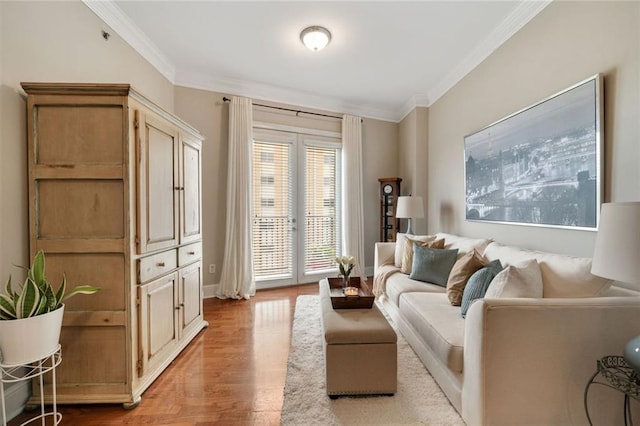 living area with ornamental molding, wood finished floors, and baseboards