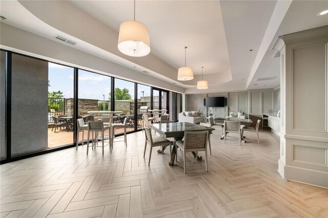 dining space featuring a raised ceiling