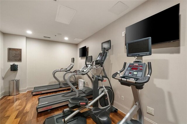 workout room featuring wood finished floors, baseboards, and recessed lighting