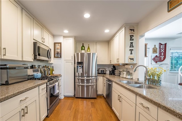 4442 Academy St, Acworth, GA 30101 - kitchen with stainless steel appliances, light wood finished floors, recessed lighting, light stone counters, and white cabinetry