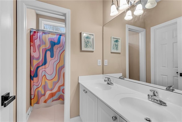bathroom with double vanity, a sink, baseboards, and a notable chandelier