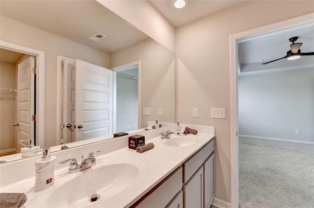 bathroom featuring ceiling fan, double vanity, visible vents, and a sink