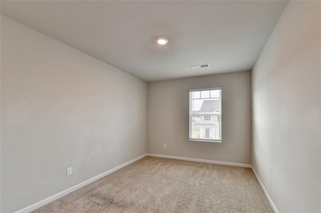 empty room with visible vents, baseboards, and light colored carpet