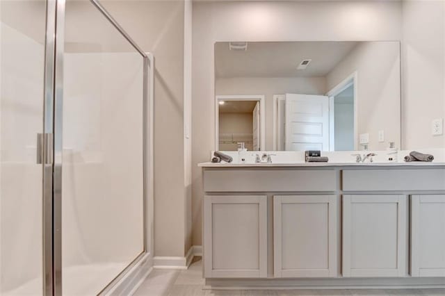 bathroom with a sink, a shower stall, and double vanity