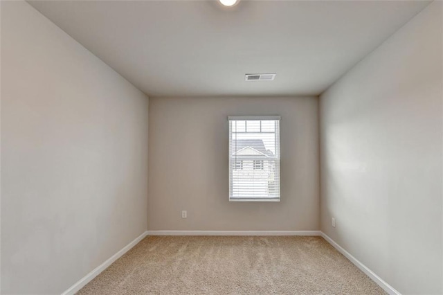 empty room with light carpet, visible vents, and baseboards