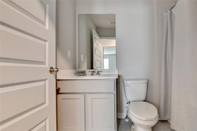 bathroom featuring vanity, toilet, and visible vents