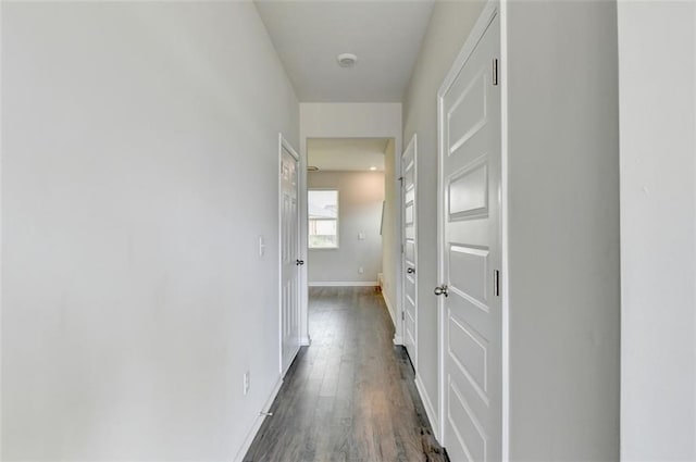 hall with dark wood-style floors and baseboards