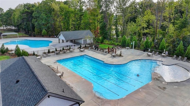 pool with a patio area and fence