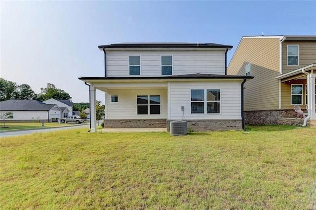 view of front of house with central AC and a front yard