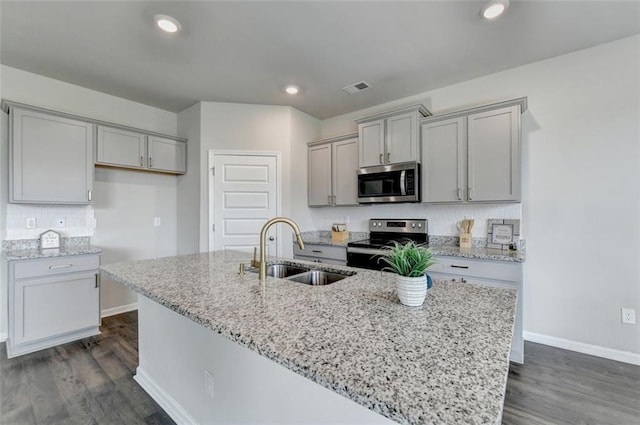 kitchen with visible vents, a sink, gray cabinets, appliances with stainless steel finishes, and dark wood-style flooring