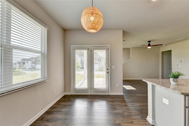 doorway with ceiling fan, baseboards, and dark wood-style floors