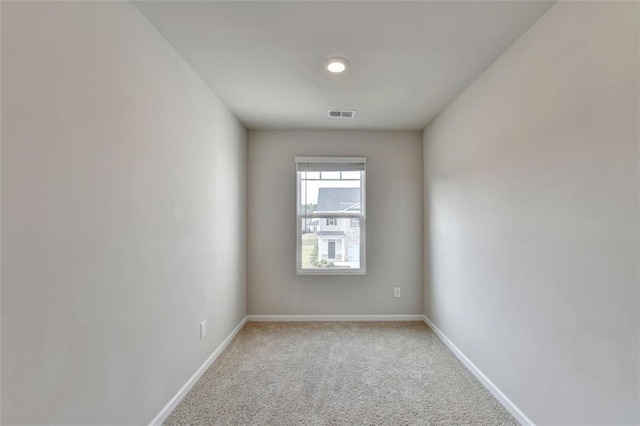 spare room featuring carpet flooring, baseboards, and visible vents