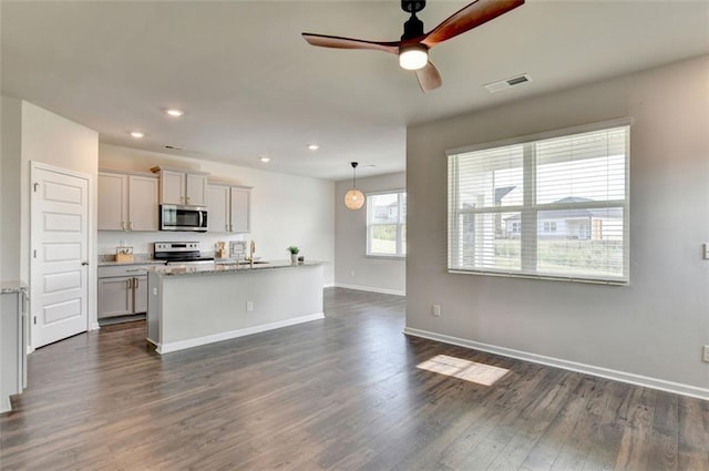 kitchen featuring visible vents, a sink, dark wood finished floors, stainless steel appliances, and baseboards