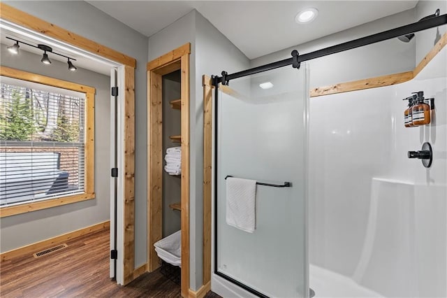 bathroom featuring a shower with door and hardwood / wood-style floors