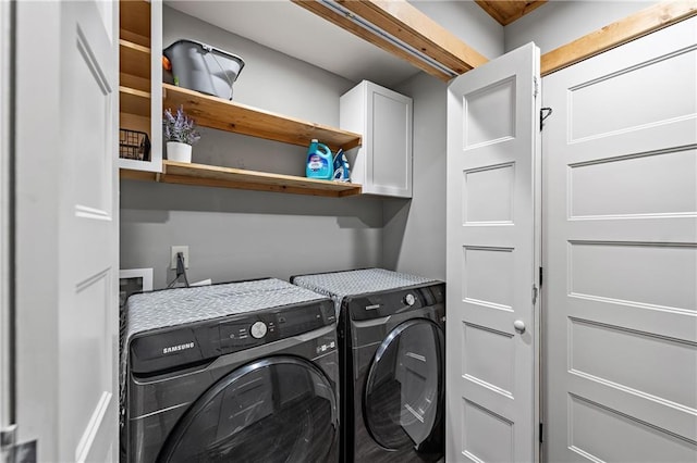 laundry room featuring cabinets and washer and clothes dryer