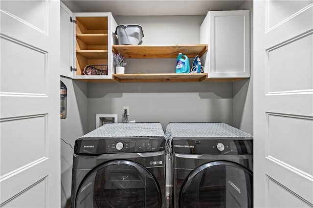 laundry room with cabinets and washing machine and clothes dryer