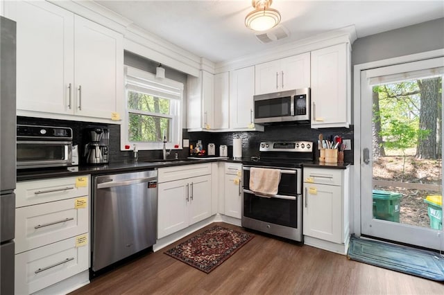 3105 Sumac Dr, Atlanta, GA 30360 - kitchen featuring appliances with stainless steel finishes, a sink, tasteful backsplash, dark wood-type flooring, and white cabinets