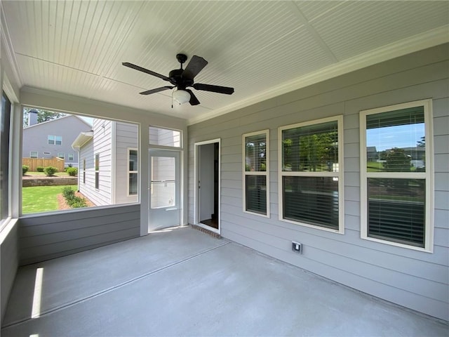 unfurnished sunroom featuring ceiling fan