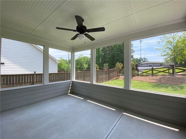 unfurnished sunroom featuring ceiling fan