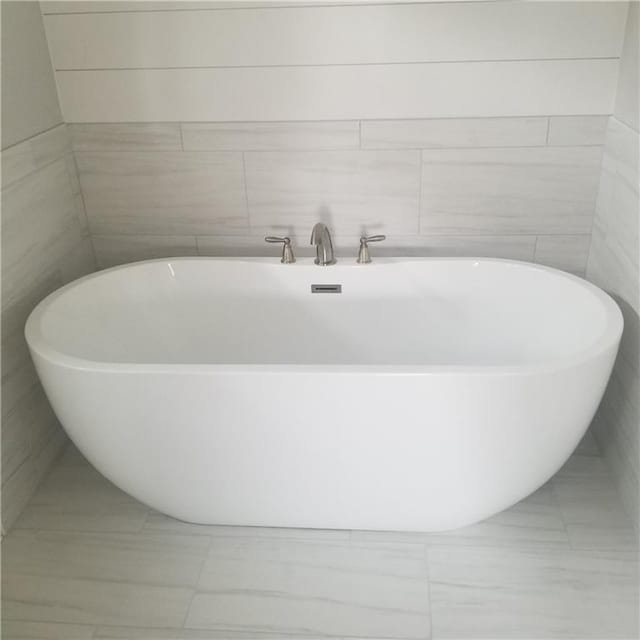 bathroom featuring tile walls and a bathtub