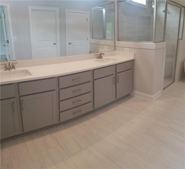 bathroom with a shower with shower door and vanity