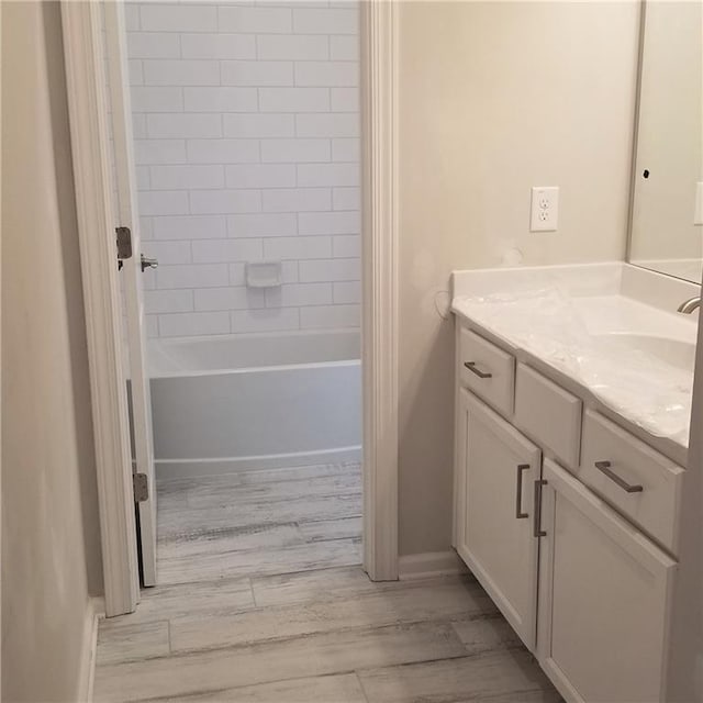 bathroom with vanity, tiled shower / bath combo, and hardwood / wood-style floors