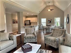 living room with ceiling fan, vaulted ceiling, dark hardwood / wood-style flooring, and ornamental molding