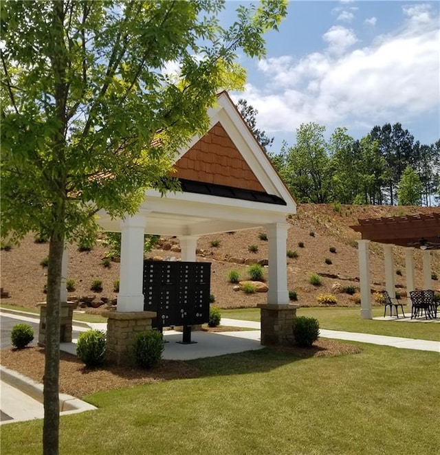 view of property's community featuring a mail area and a yard