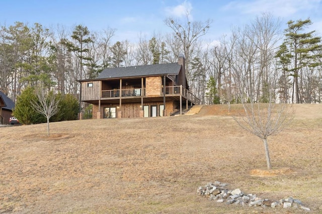 back of house with a wooden deck and a chimney