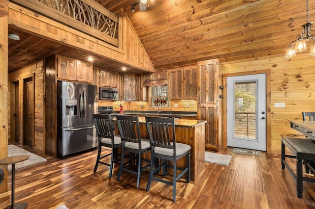 kitchen featuring stainless steel appliances, wood ceiling, dark wood finished floors, and wood walls